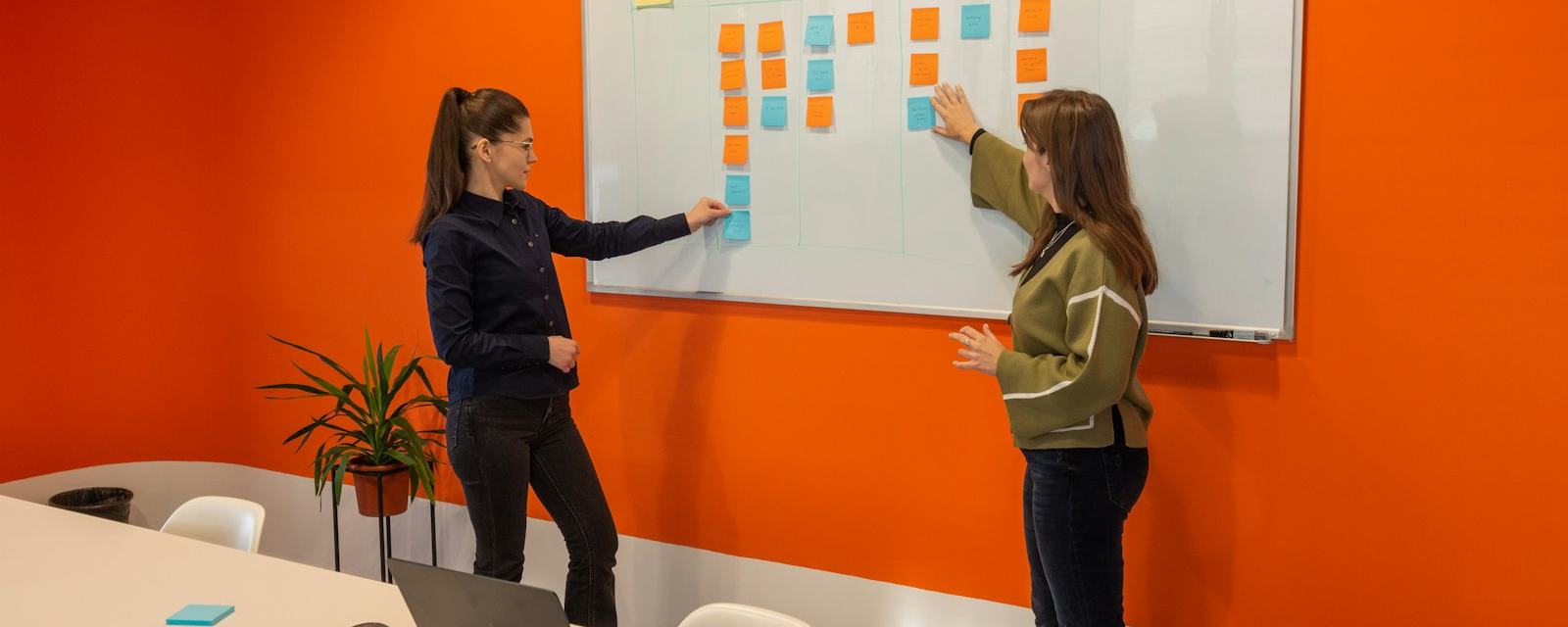 Two colleagues mapping a plan on a whiteboard